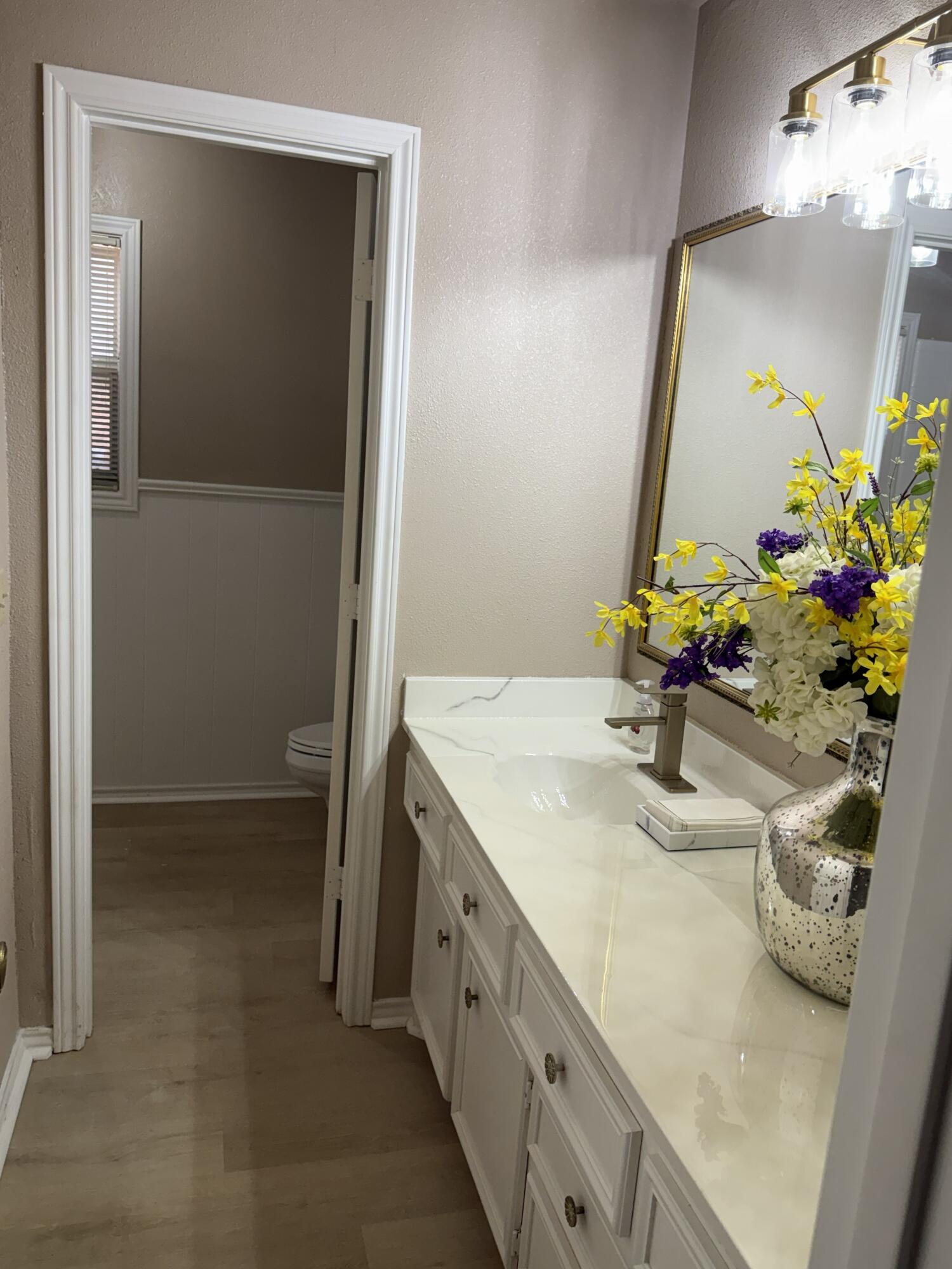 5722 75th Street Lubbock, TX 79424 - Photo 15 of 29 a bathroom with a double vanity sink and a mirror