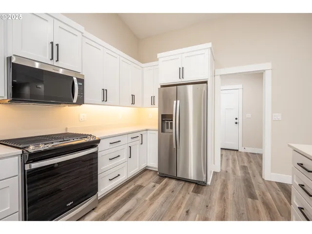 a kitchen with stainless steel appliances a stove microwave and refrigerator