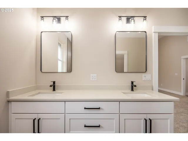 a bathroom with double vanity sinks and two mirror