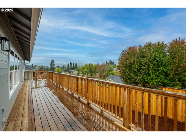a view of balcony with wooden floor and fence
