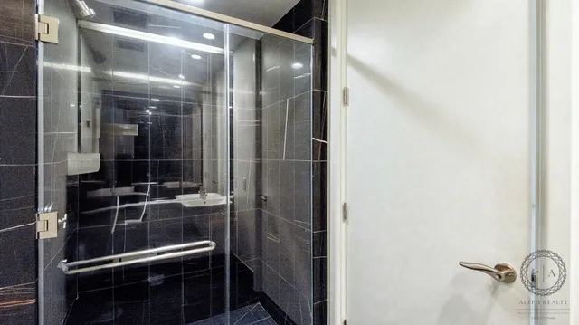 a bedroom with a bed and a lamp on dresser