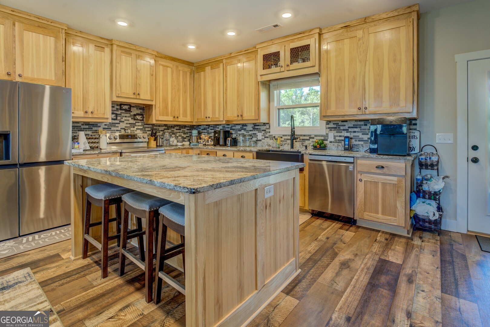 4348 Marshall Stewart Road Southwest Crawfordville, GA 30631 - Photo 12 of 120 a kitchen with stainless steel appliances granite countertop a table chairs sink refrigerator and cabinets