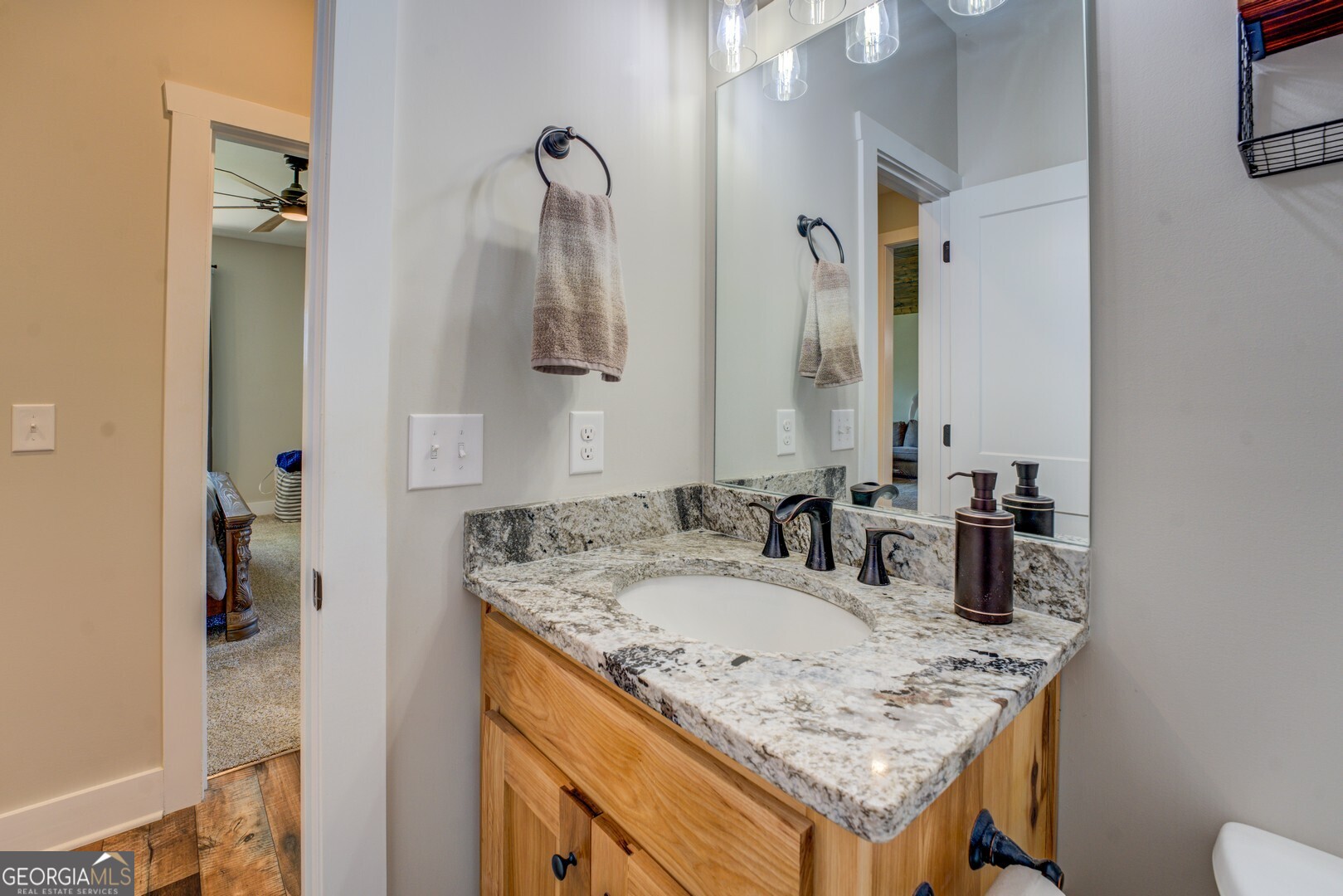 4348 Marshall Stewart Road Southwest Crawfordville, GA 30631 - Photo 36 of 120 a bathroom with a granite countertop sink and a mirror