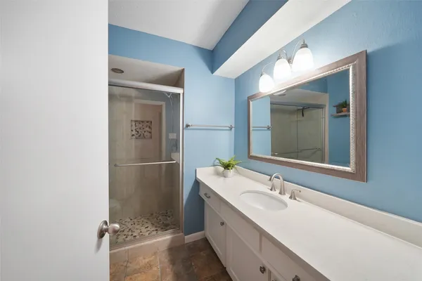 a bathroom with a double vanity sink mirror and shower