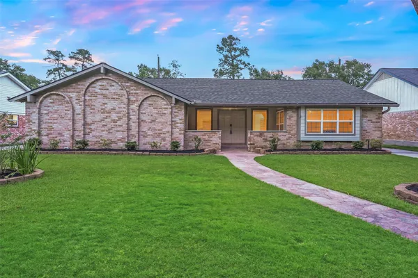 a front view of a house with a garden and yard