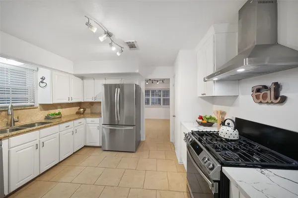 a kitchen with stainless steel appliances granite countertop a sink and a stove