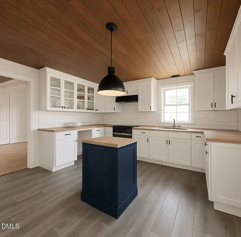 a kitchen with stainless steel appliances granite countertop a sink a stove and white cabinets with wooden floor