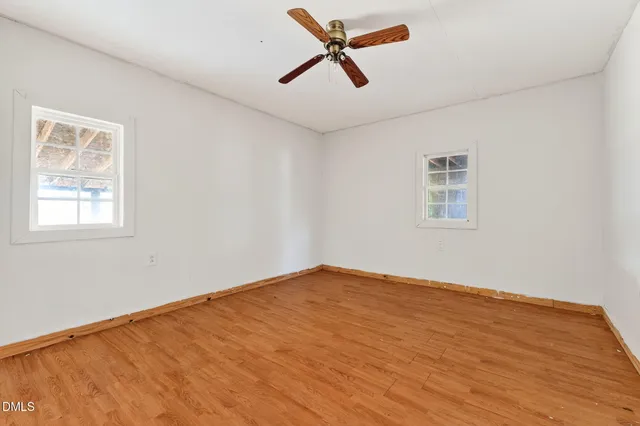 a view of empty room with wooden floor