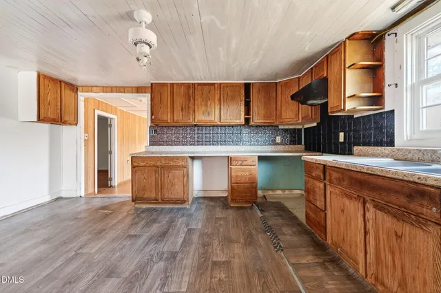 a kitchen with kitchen island granite countertop wooden floors and stainless steel appliances