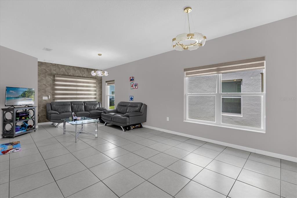 3470 Beau Road Kissimmee, FL 34746 - Photo 8 of 40 a living room with furniture a dining table and a window