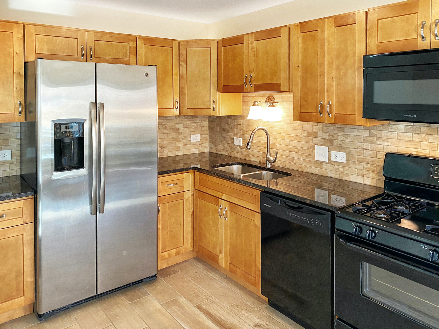 131 Century Court, Unit O2 Schaumburg, IL 60193 - Photo 6 of 16 a kitchen with stainless steel appliances granite countertop a refrigerator a stove and a sink