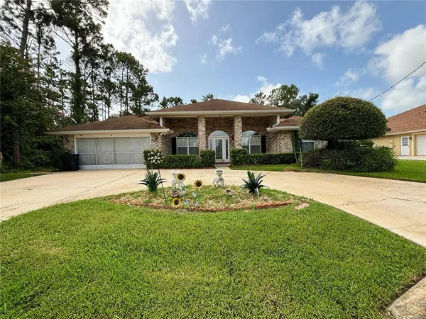 a front view of a house with yard and green space