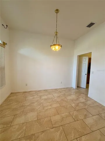 a view of a room with a chandelier fan and windows