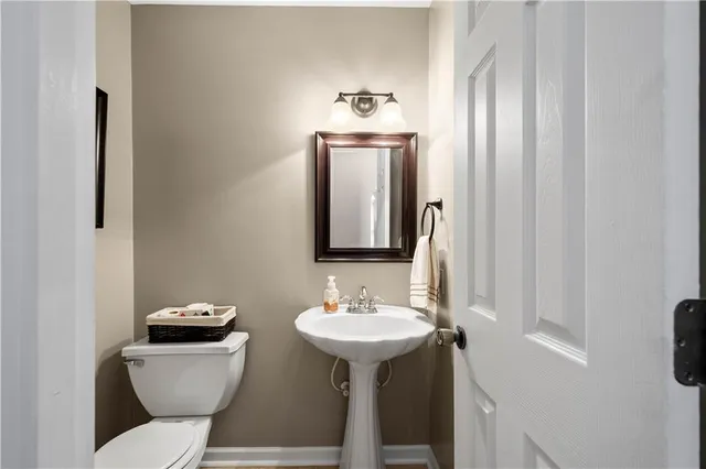 a bathroom with a sink toilet and mirror