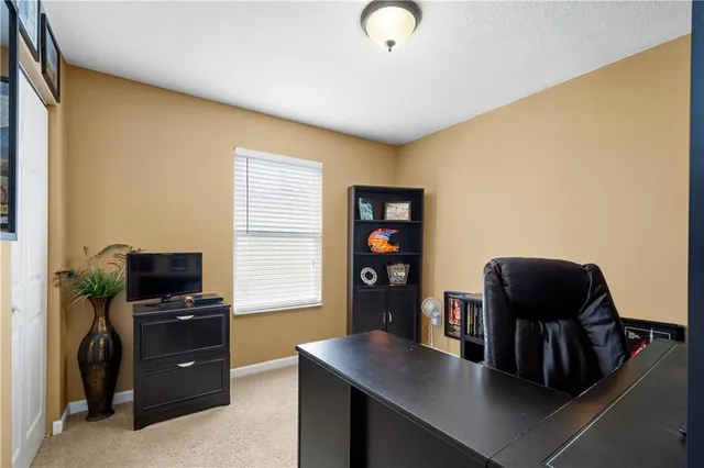 a view of a workspace with furniture and a window