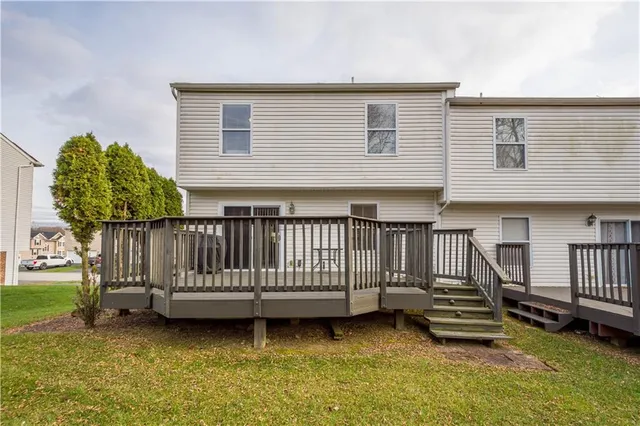 a view of a house with wooden floor roof and a small yard