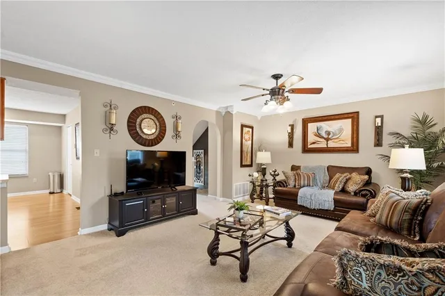 a living room with furniture a clock and a flat screen tv