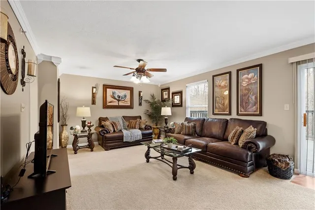 a living room with furniture ceiling fan and a window