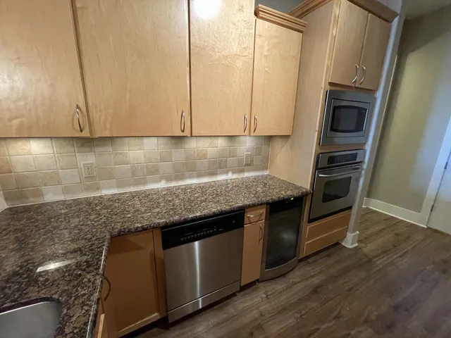 a kitchen with granite countertop a sink a stove and cabinets