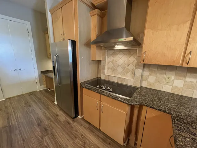 a kitchen with granite countertop a stove and a refrigerator