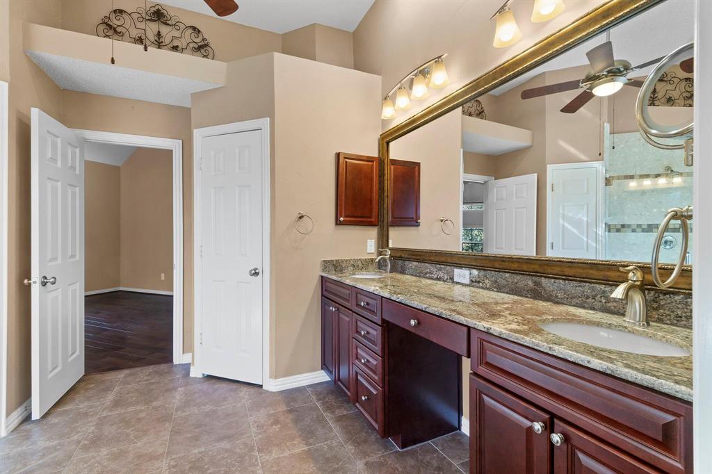 14588 Poe Court Addison, TX 75001 - Photo 19 of 28 a bathroom with a granite countertop sink and a mirror