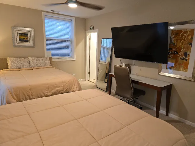 a bedroom with two bed and a flat screen tv