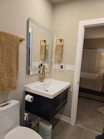 a bathroom with a sink toilet and mirror