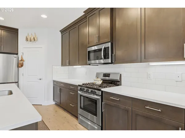 a kitchen with stainless steel appliances granite countertop a stove a sink and a microwave