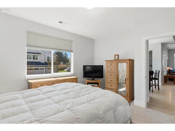 a bedroom with a bed flat screen tv and a large window