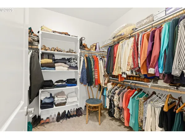 a view of walk in closet with clothes and shoes