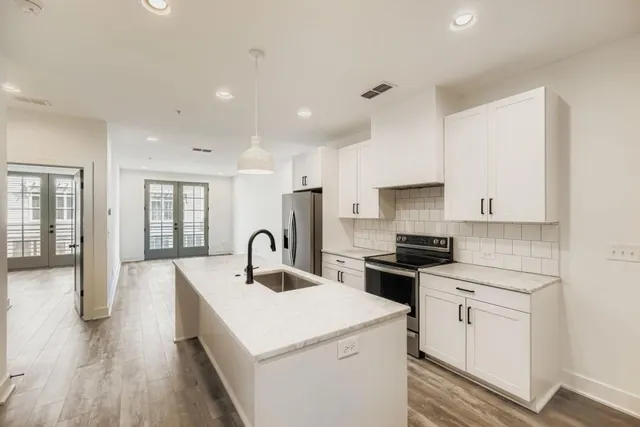 a kitchen with white cabinets appliances and sink