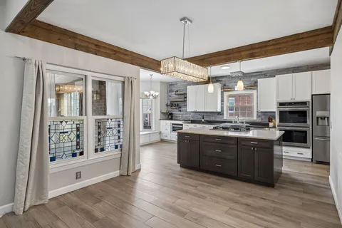 a kitchen with stainless steel appliances a sink stove and cabinets