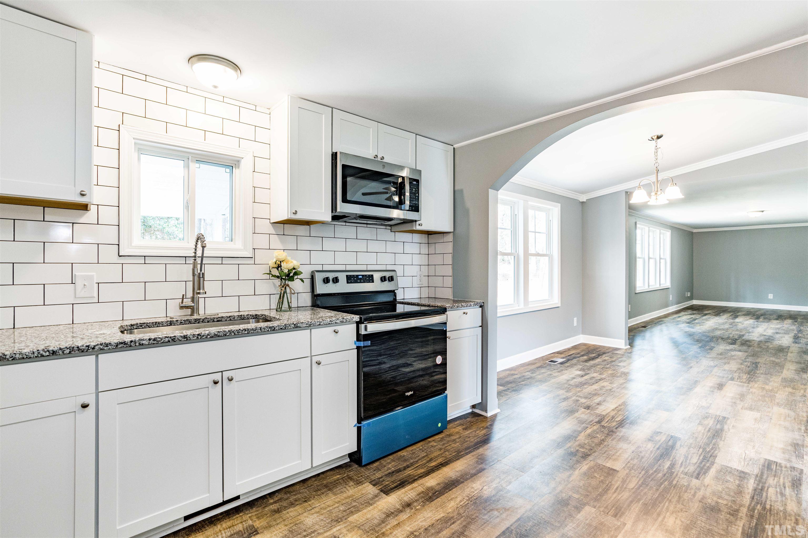1100 Yakimas Road Raleigh, NC 27603 - Photo 12 of 26 a kitchen with stainless steel appliances granite countertop a stove sink and cabinets