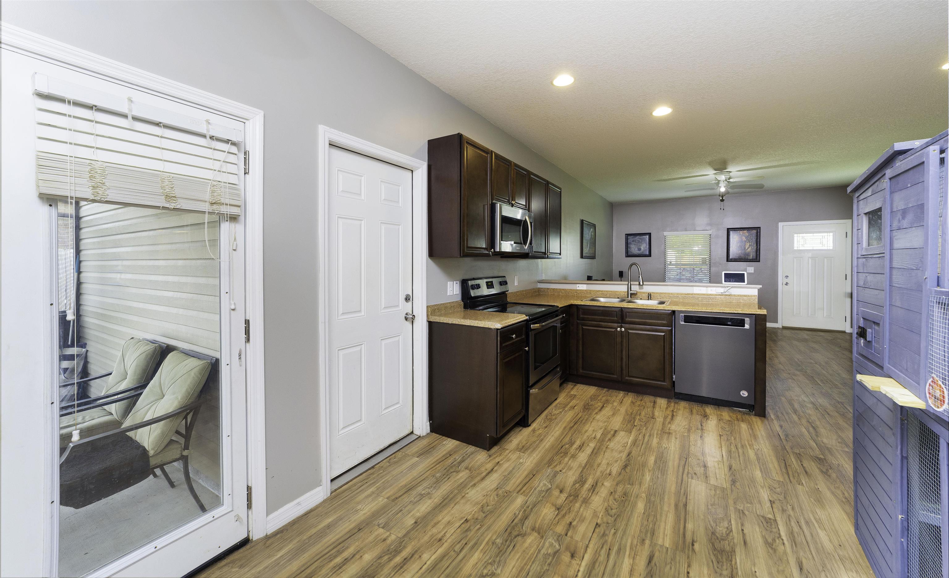 122 Osprey Road St. Augustine, FL 32086 - Photo 17 of 50 a kitchen with stainless steel appliances granite countertop a stove top oven a sink dishwasher a refrigerator and a dining table with wooden floor