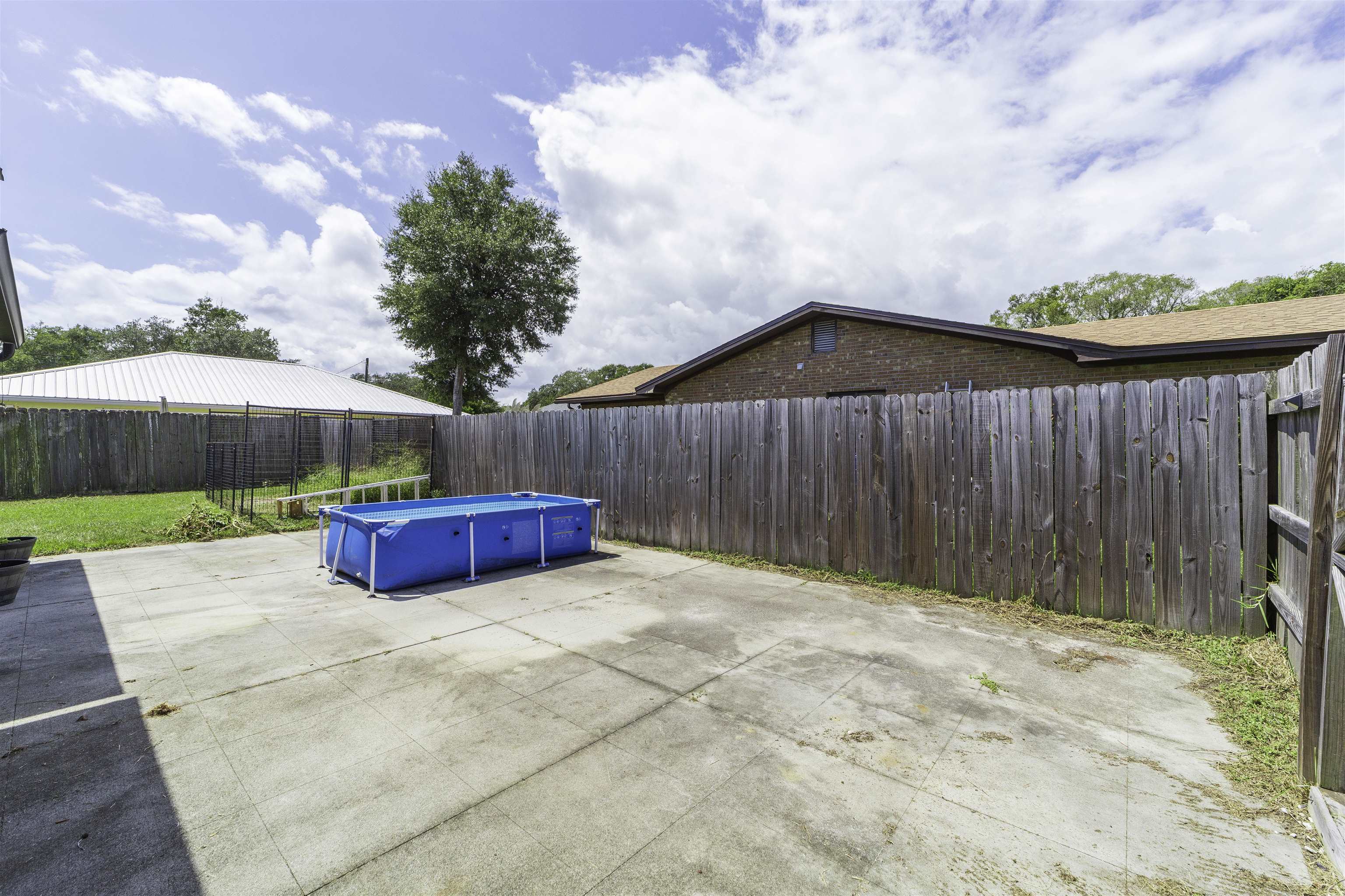 122 Osprey Road St. Augustine, FL 32086 - Photo 40 of 50 a view of a backyard with a barbeque and wooden fence
