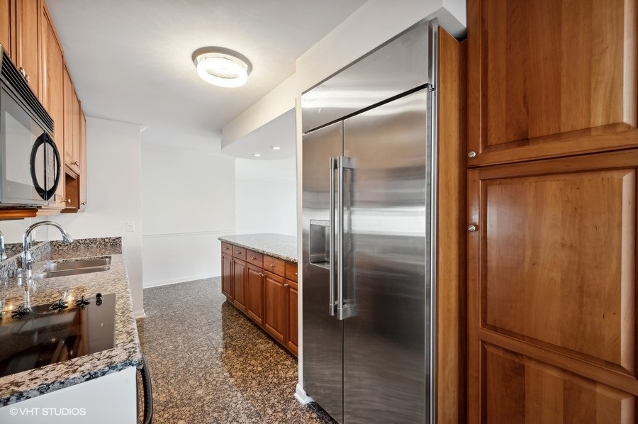 111 East Chestnut Street, Unit 14K Chicago, IL 60611 - Photo 13 of 20 a kitchen with stainless steel appliances granite countertop a refrigerator and a stove