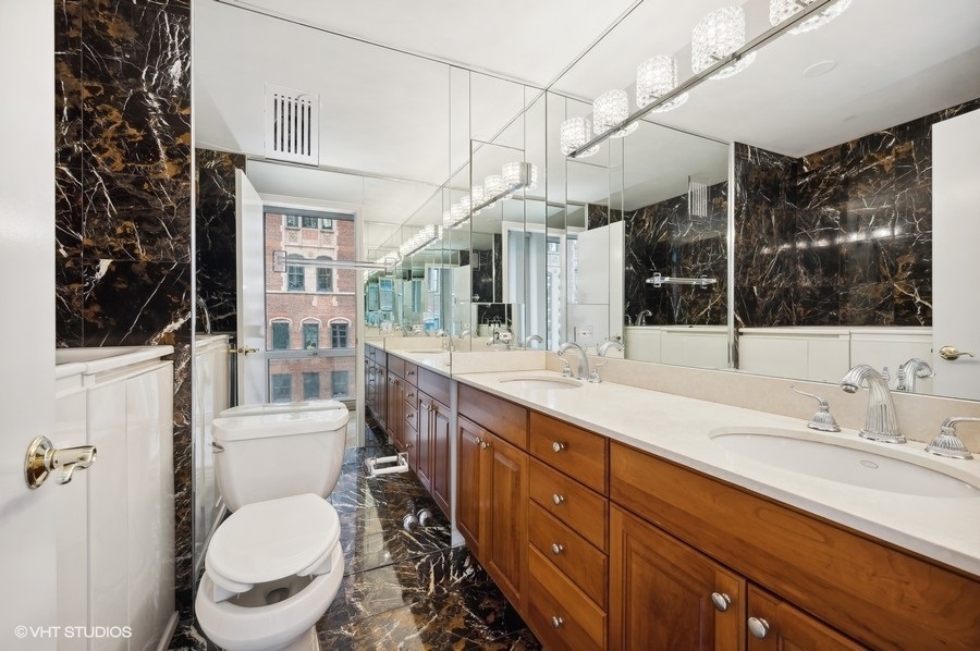 111 East Chestnut Street, Unit 14K Chicago, IL 60611 - Photo 16 of 20 a spacious bathroom with a toilet sink double vanity and mirror