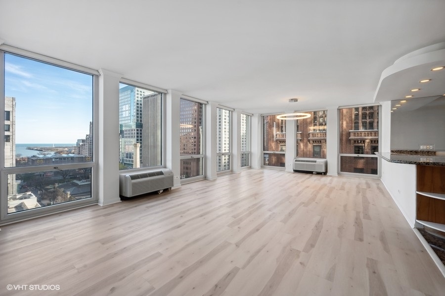111 East Chestnut Street, Unit 14K Chicago, IL 60611 - Photo 2 of 20 a view of empty room with a floor to ceiling window and wooden floor