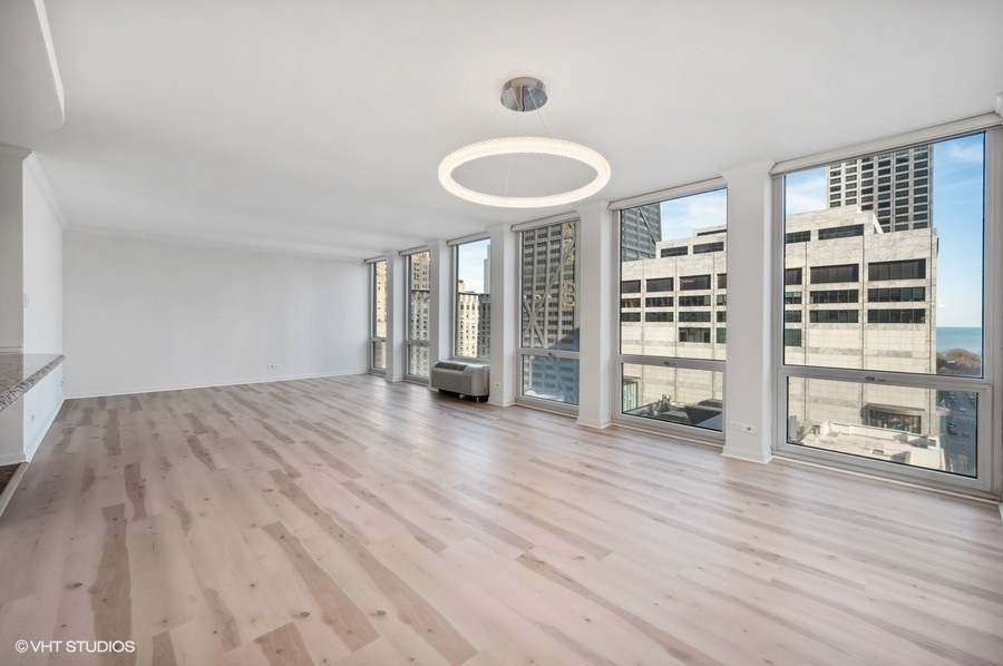 111 East Chestnut Street, Unit 14K Chicago, IL 60611 - Photo 3 of 20 an empty room with wooden floor and windows