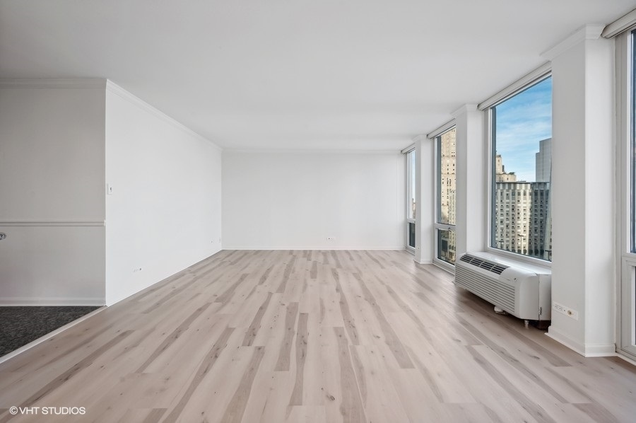 111 East Chestnut Street, Unit 14K Chicago, IL 60611 - Photo 8 of 20 wooden floor in an empty room with a window