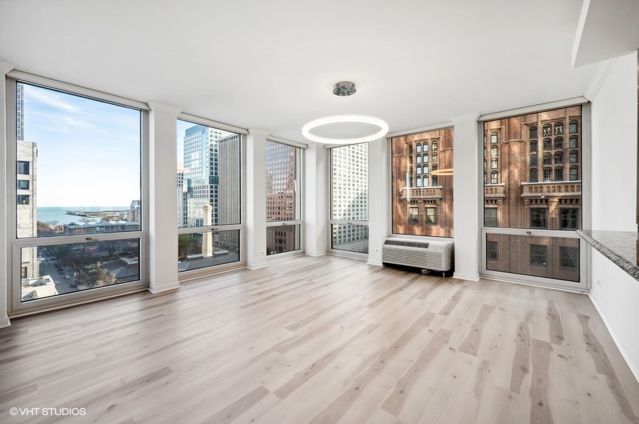 111 East Chestnut Street, Unit 14K Chicago, IL 60611 - Photo 10 of 20 an empty room with wooden floor and windows