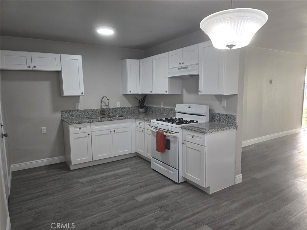 2140 Mahoney Drive Bakersfield, CA 93307 - Photo 12 of 16 a kitchen with granite countertop white cabinets and white appliances