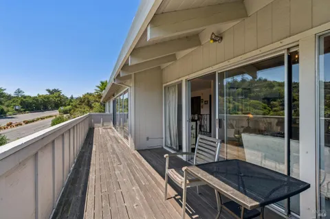 a balcony with wooden floor and outdoor seating