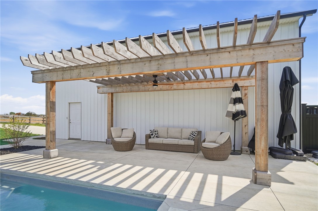 7823 Township Line Road Waynesville, OH 45068 - Photo 12 of 22 An inviting poolside retreat offers shaded lounging under a wooden pergola, perfect for relaxation.