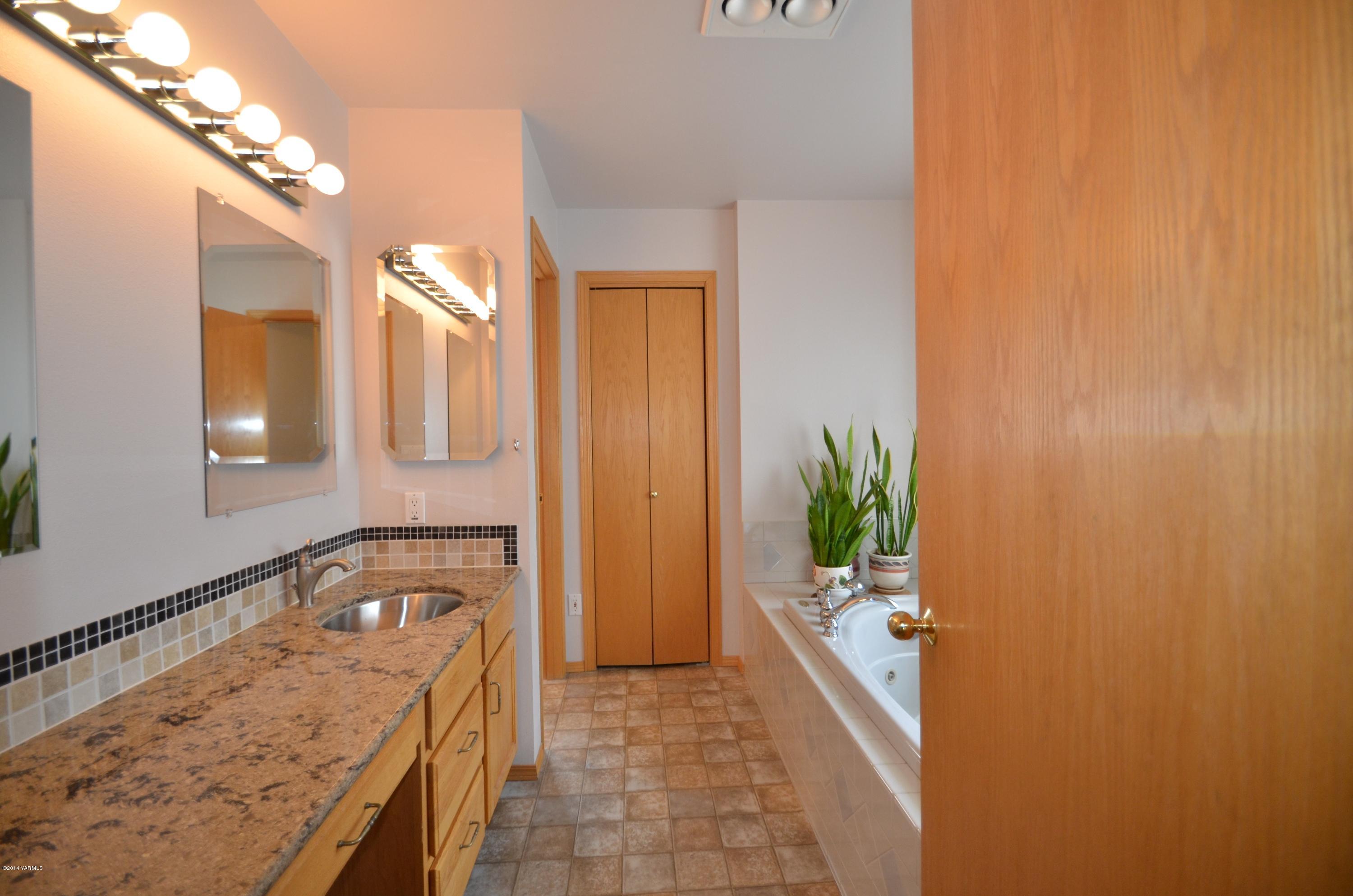 5405 Postma Road Yakima, WA 98901 - Photo 12 of 31 a bathroom with a tub sink and mirror
