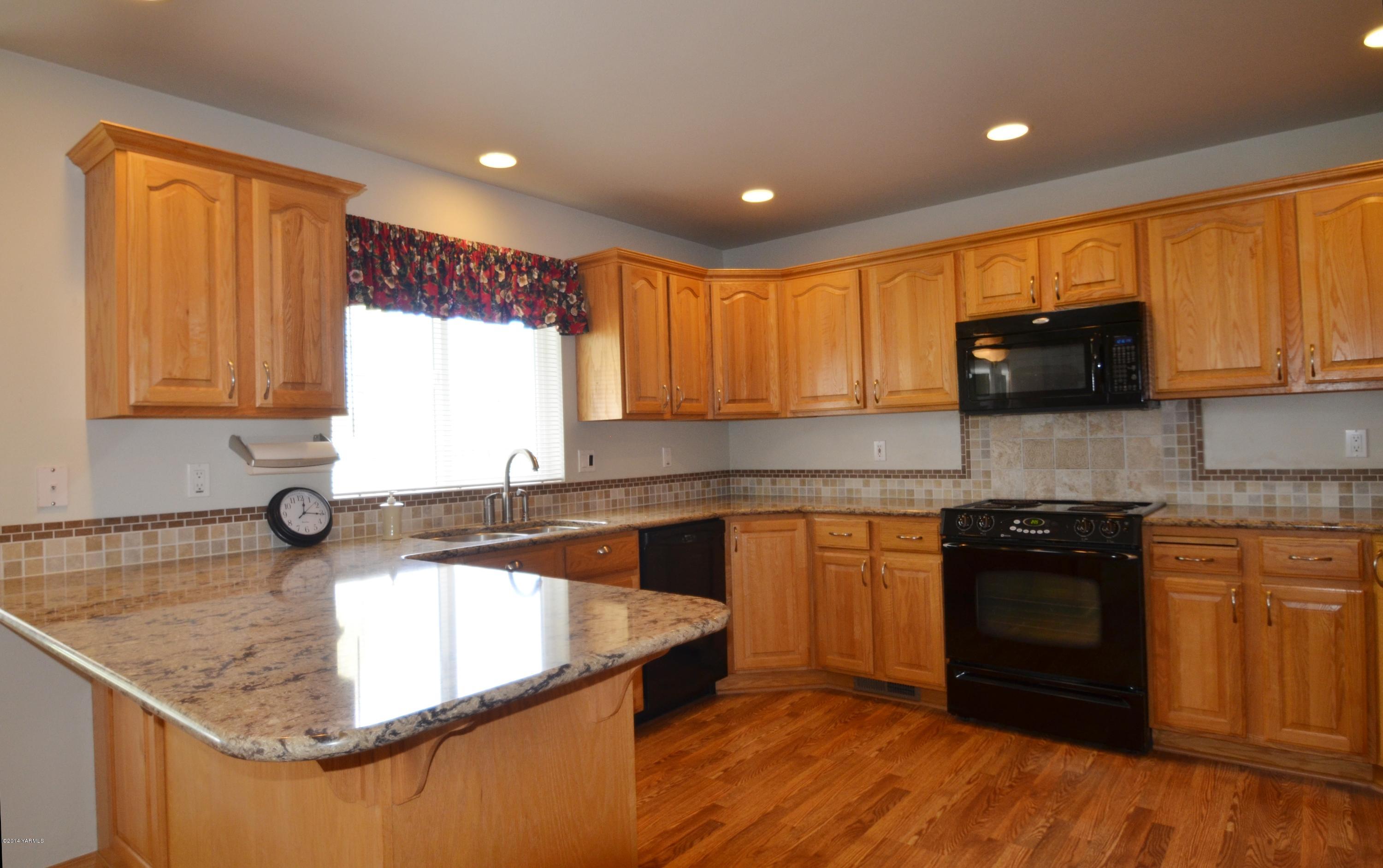 5405 Postma Road Yakima, WA 98901 - Photo 7 of 31 a kitchen with granite countertop wooden cabinets granite counter tops and a stove