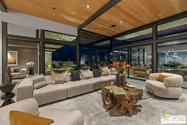 a living room with furniture and a floor to ceiling window