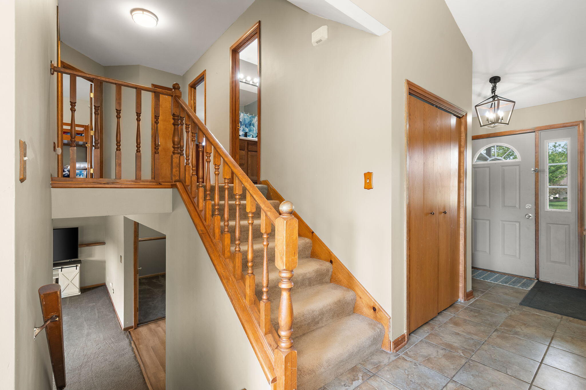 8987 Calhoun Place Crown Point, IN 46307 - Photo 12 of 28 a view of staircase with lots of frames and frames on wall door