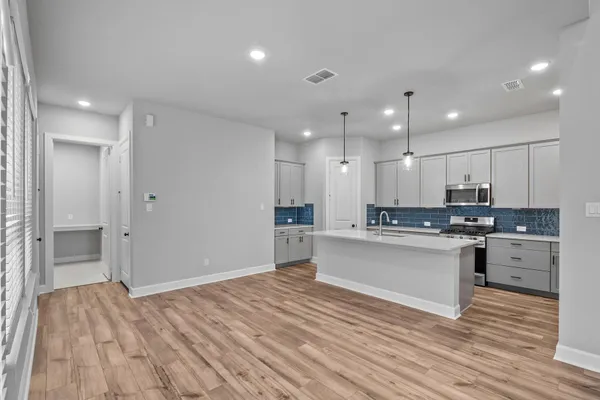 a large kitchen with kitchen island a sink stainless steel appliances and cabinets