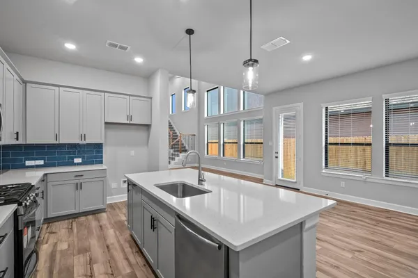 a kitchen that has a lot of cabinets in it and wooden floors